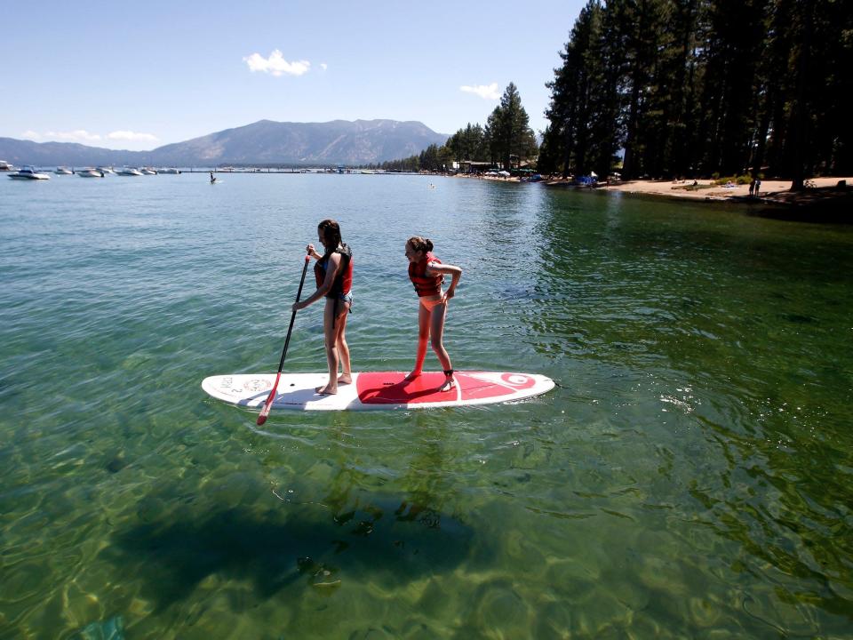 Deux touristes font du paddle board sur le lac Tahoe en 2019.