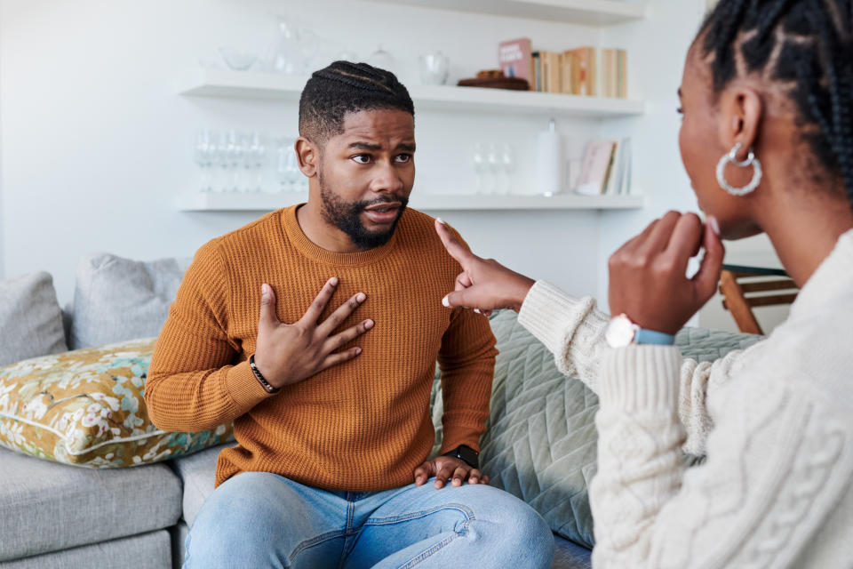 Two people engaged in a serious conversation, gesturing with their hands. One person listens intently