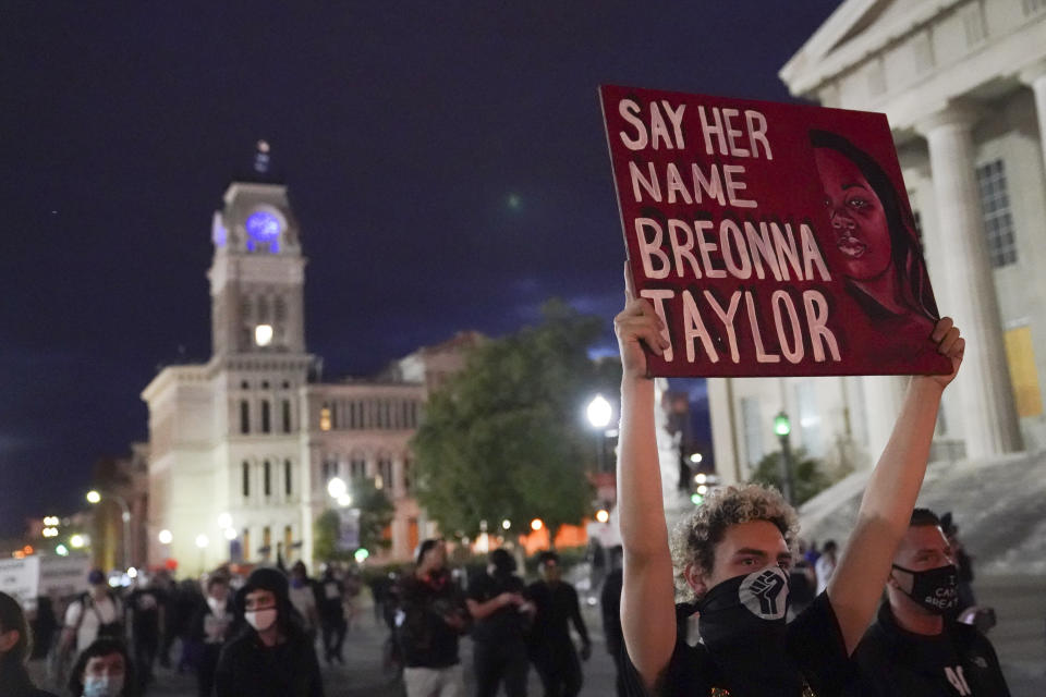 FILE - In this Sept. 24, 2020 file photo, protesters march in Louisville, Ky. The three Louisville police officers who fired their guns in the fatal raid at Breonna Taylor’s apartment avoided homicide charges. But an ongoing federal probe could expand beyond the officers who conducted the raid. The warrant that sent the police to Taylor’s home a year ago and how it was obtained are under review by federal investigators. And there are signs the investigation could range into the Louisville police response to protests after the shooting. (AP Photo/John Minchillo, file)