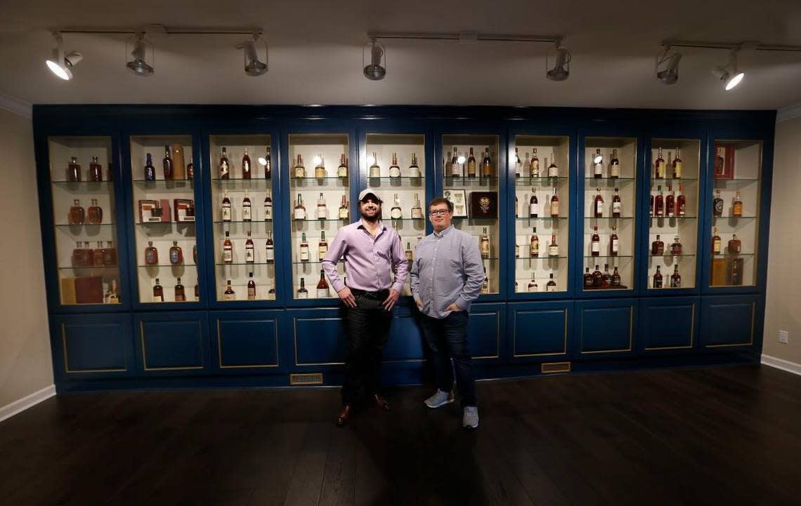 Justin Thompson, left and Justin Sloan, right, in the vintage bourbon room at their Justins’ House of Bourbon at the corner of Jefferson and West Main streets. Many of the bottles came from their personal collections.