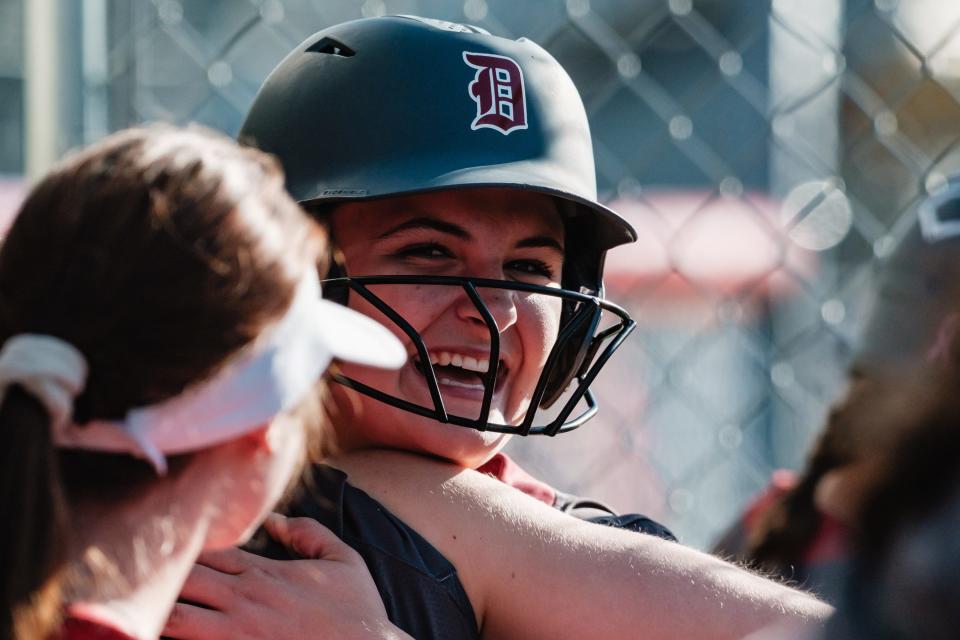 Dover's Olivia McCue, a freshman, is embraced by teammates after crushing a 3-run home run during a DII Sectional Final game against Indian Valley, Friday, May 10 in Dover.