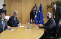 FILE - In this Tuesday, Feb. 18, 2020 file photo Eurogroup President and Portugal's Finance Minister Mario Centeno, third left, meets with European Council President Charles Michel, second right, at the Europa building in Brussels. Governments from the 19 countries that use the euro overcame sharp differences to agree Thursday on measures that could provide more than a half-trillion euros ($550 billion) for companies, workers and health systems to cushion the economic impact of the virus outbreak. Mario Centeno, who heads the finance ministers' group from euro countries, called the package of measures agreed upon "totally unprecedented... Tonight Europe has shown it can deliver when the will is there." (AP Photo/Virginia Mayo, Pool, File)