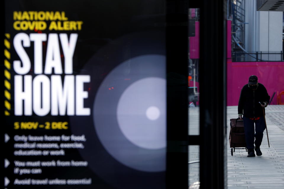 A man walks past a sign displaying the measures imposed by the government against the outbreak of the coronavirus disease (COVID-19), on the first day of a newly imposed lockdown, in London, Britain, November 5, 2020. REUTERS/John Sibley