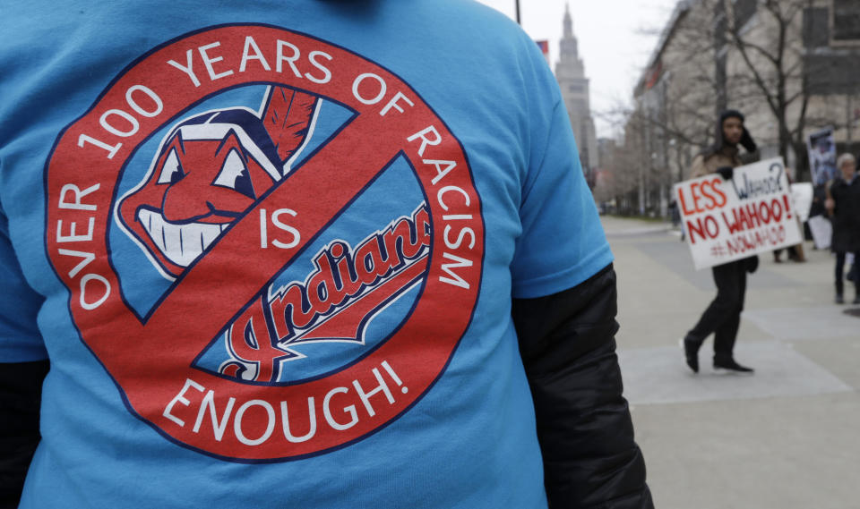 A man wears a shirt in protest of Chief Wahoo before a home opener baseball game between the Kansas City Royals and the Cleveland Indians, Friday, April 6, 2018, in Cleveland. (AP Photo/Tony Dejak)