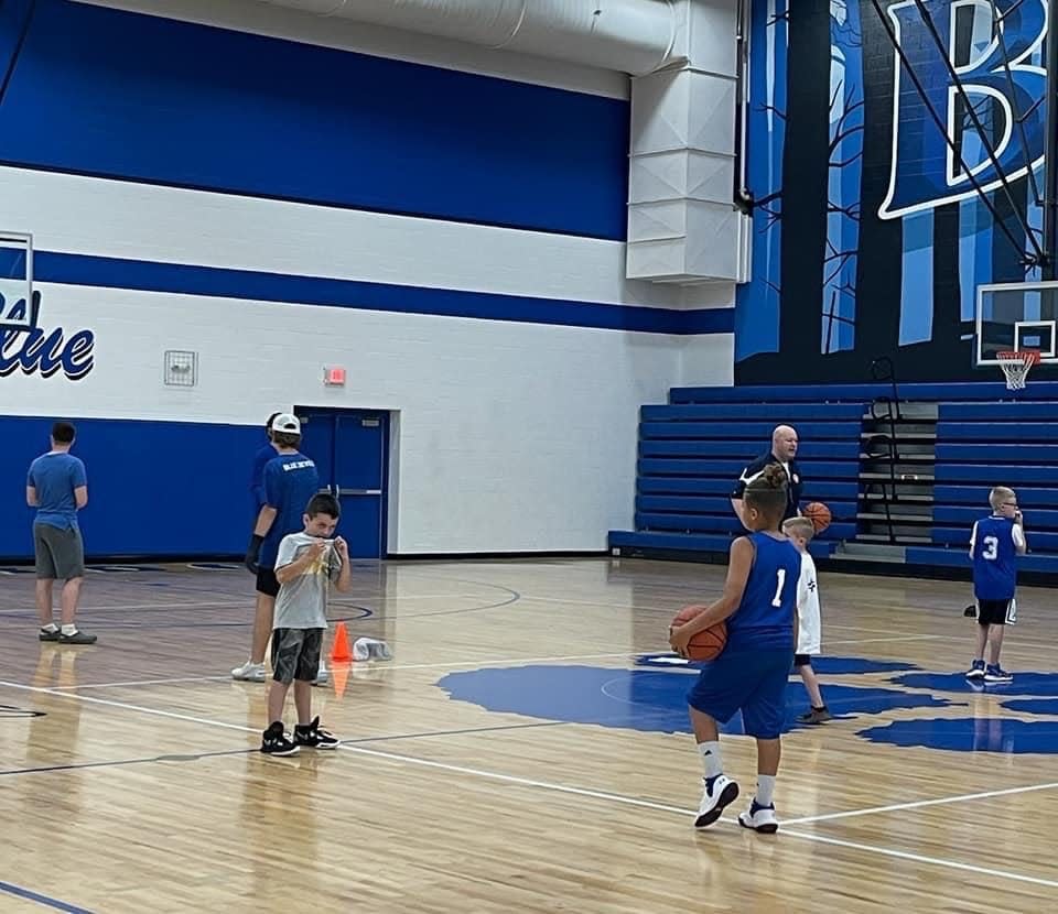 Cambridge High head boys basketball coach Kyle Pertuset, right,  gives some instructions to a group of young campers during one of three sessions put on by Pertuset, his coaching staff and varsity players this summer.