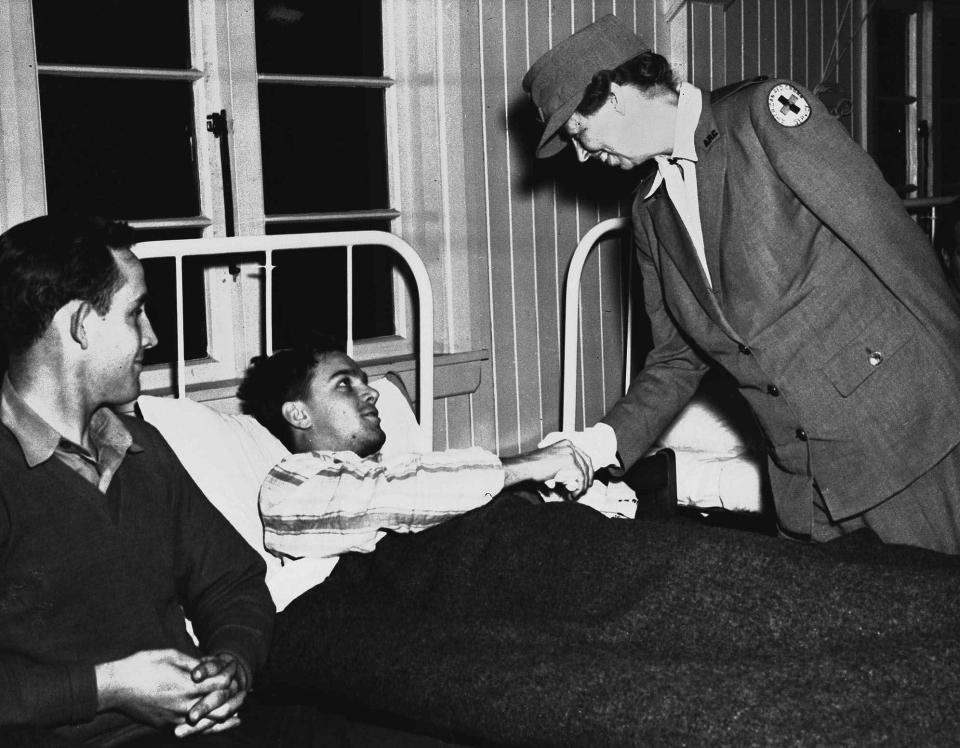 First lady Eleanor Roosevelt, on a tour of the South Pacific, stops to chat with a U.S. Marine patient in a naval hospital on Sept. 23, 1943. During World War II, Roosevelt toured American airfields in Britain and visited the wounded on Guadalcanal.