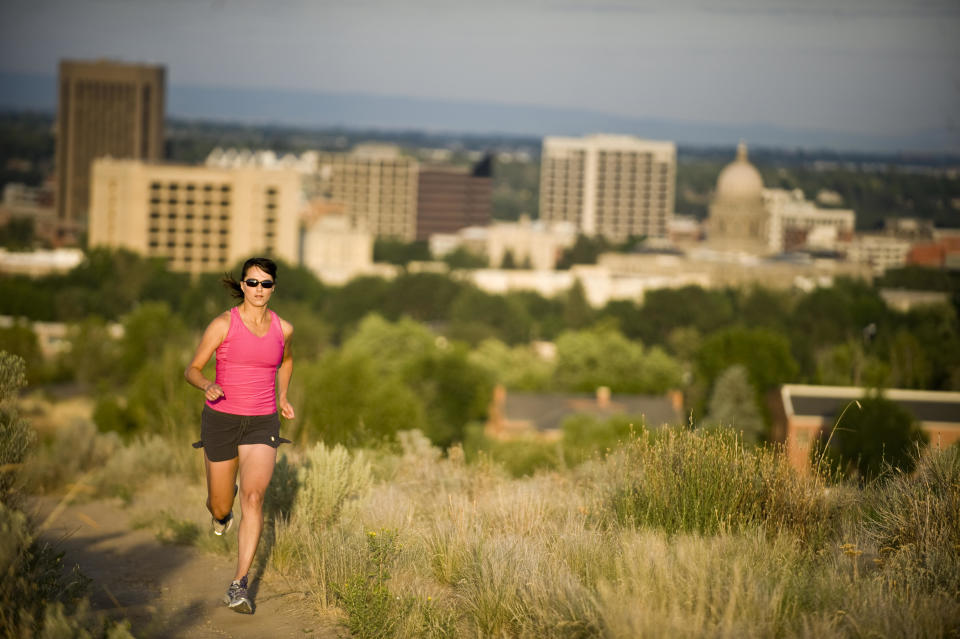 A woman runs on a trail with downtown Boise, Idaho, visible in the background. / Credit: Lee Cohen/Getty Images