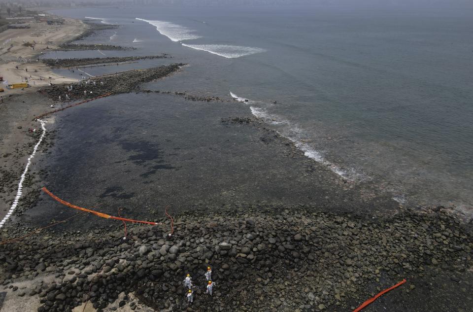 Workers continue in a clean-up campaign after an oil spill, on Pocitos Beach in Ancon, Peru, Tuesday, Feb. 15, 2022. One month later, workers continue the clean-up beaches after contamination by a Repsol oil spill. (AP Photo/Martin Mejia)