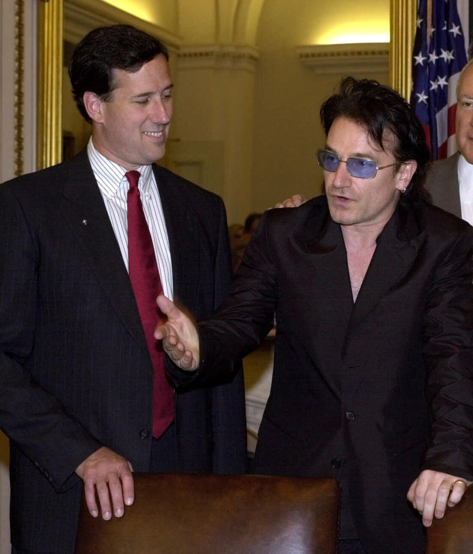 FILE - In this June 13, 2001 file photo, U2 lead singer Bono, discusses the global AIDS crises with then-Sen. Rick Santorum, R-Pa., on Capitol Hill in Washington. Rick Santorum boasts that deep conservative values make him a stronger challenger against President Barack Obama this fall than likely GOP nominee Mitt Romney. (AP Photo/Dennis Cook, File)