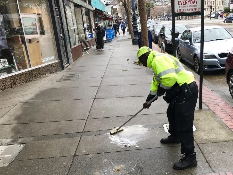 A Castro CBD crew member cleaning the sidewalk along Market Street.
