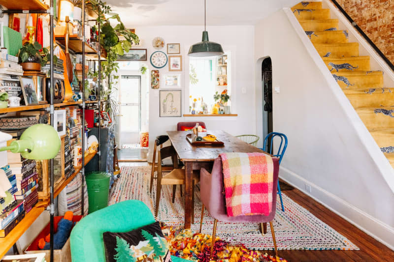 Living room with wall-mounted shelving and wooden table.