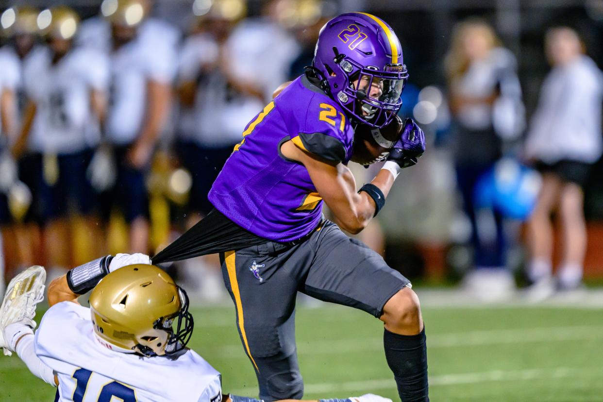 Hickman's Jeyshan Scott (21) tries to break away from a Helias defender