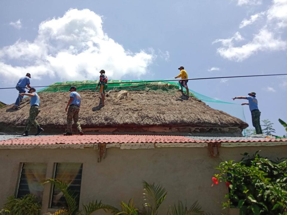 Police help residents reinforce the roof of their homes in Ivana town, Batanes province, on the very tip of the Philippines (Ivana Police station/AFP/Getty)