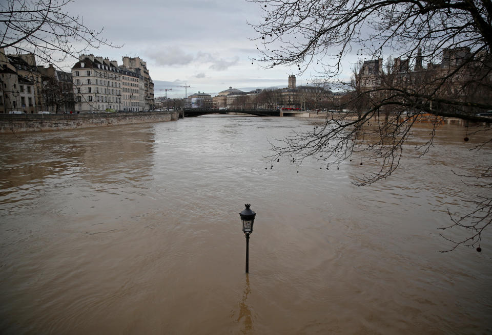 <p>A street-lamp is seen on the flooded banks of the Seine River in Paris, France, after days of almost non-stop rain caused flooding in the country, Jan. 24, 2018. (Photo: Christian Hartmann/Reuters) </p>