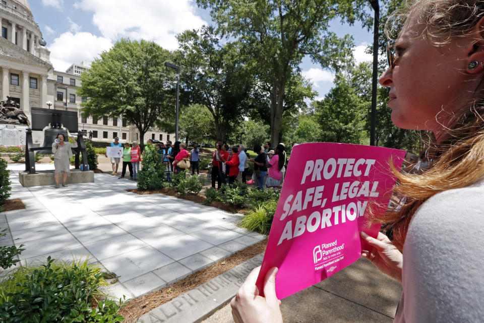 FILE - In this Tuesday, May 21, 2019 file photo, An abortion rights advocate holds a sign at the Capitol in Jackson, Miss. Republican lawmakers in at least a half dozen GOP-controlled states already are talking about copying a Texas law that bans abortions after a fetal heartbeat is detected. The law was written in a way that was intended to avoid running afoul of federal law by allowing enforcement by private citizens, not government officials. Democratic governors and lawmakers are promising to take steps to protect abortion rights, after the U.S. Supreme Court allowed the Texas law to stand. (AP Photo/Rogelio V. Solis, File)