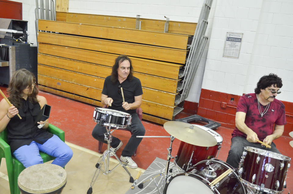 Vinny and Carmine Appice jam on the drums while volunteer Amy Garapic trades her bongos for some cow bell.