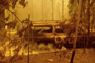 A scorched car rests in a clearing following the Bear Fire in Butte County, Calif., on Wednesday, Sept. 9, 2020. The blaze, part of the lightning-sparked North Complex, expanded at a critical rate of spread as winds buffeted the region. (AP Photo/Noah Berger)