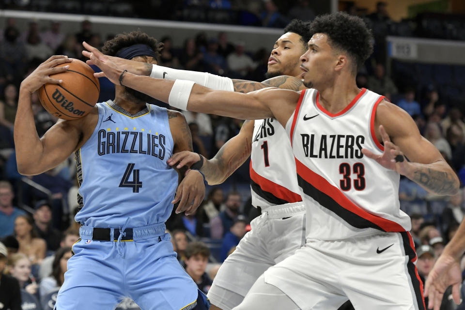 Portland Trail Blazers forward Toumani Camara (33) and guard Anfernee Simons (1) defend against Memphis Grizzlies guard Jordan Goodwin (4) during the first half of an NBA basketball game Saturday, March 2, 2024, in Memphis, Tenn. (AP Photo/Brandon Dill)