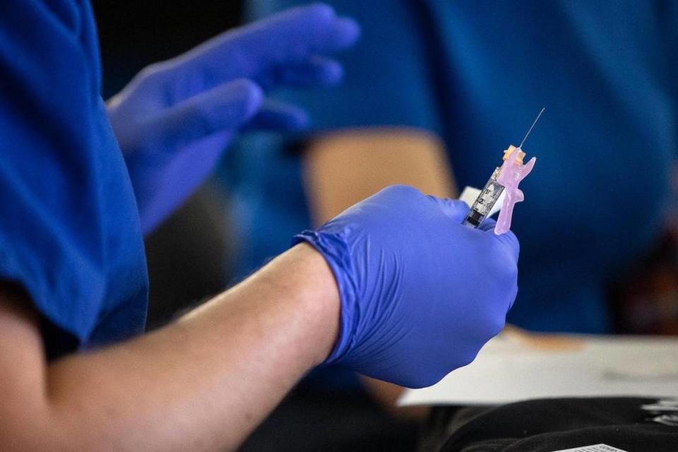 A health care worker preparers a dose of the COVID-19 vaccine at the University of Kentucky HealthCare Vaccination Program at Kroger Field in Lexington, Ky., Tuesday, Jan. 19, 2021.