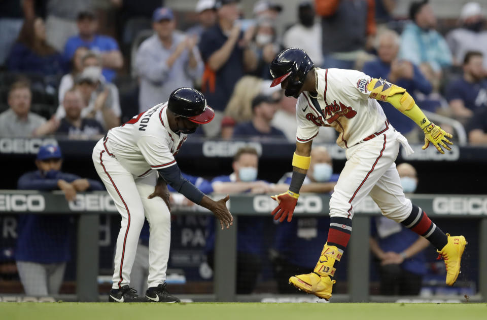 Atlanta Braves' Ronald Acuna Jr., right, celebrates with third base coach Ron Washington after hitting a home run off Toronto Blue Jays pitcher Robbie Ray in the third inning of a baseball game Tuesday, May 11, 2021, in Atlanta. (AP Photo/Ben Margot)