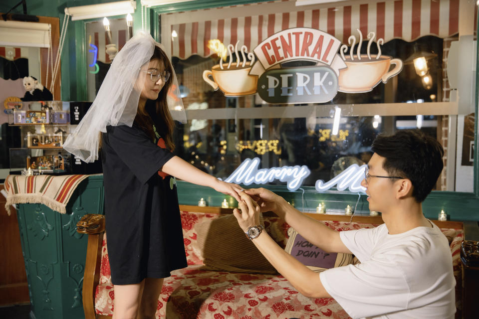 In this photo released by Zhang Fengguang, Zhang Fengguang, right, proposes to his fiancee Sun Tiantian by recreating the Chandler and Monica's proposal scene from the hit sit-com "Friends" in the Shenzhen Central Perk cafe which is styled to look like the setting in the series in the southern China city of Shenzhen, on Sept. 22, 2023. As Hollywood and beyond mourns the death of Perry, who starred as Chandler Bing on the popular show for 10 seasons, fans in China are also feeling the loss of the beloved actor who died on Oct. 28, 2023 in Los Angeles. (Zhang Fengguang via AP)