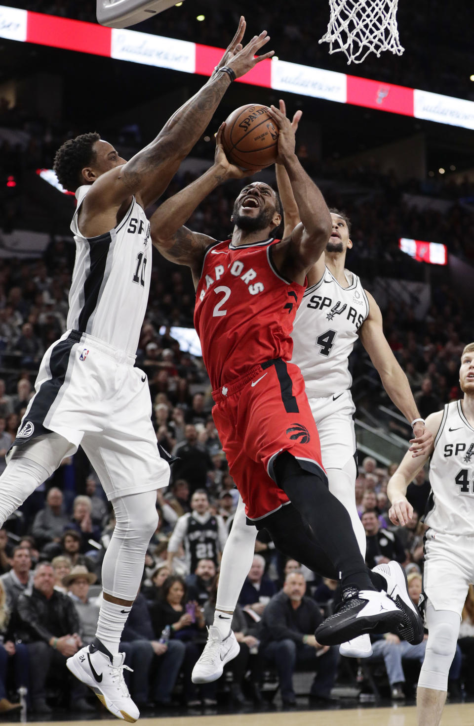 Toronto Raptors forward Kawhi Leonard (2) is blocked as he drives to the basket against San Antonio Spurs guard DeMar DeRozan (10) and guard Derrick White (4) during the first half of an NBA basketball game, Thursday, Jan. 3, 2019, in San Antonio. (AP Photo/Eric Gay)