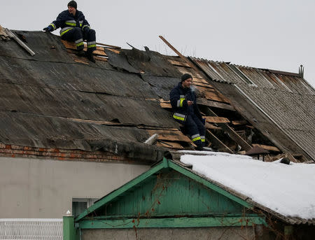 Emergencies Ministry members rest as they repair a building which was damaged during fighting between the Ukrainian army and pro-Russian separatists in the government-held industrial town of Avdiyivka, Ukraine, February 6, 2017. REUTERS/Gleb Garanich