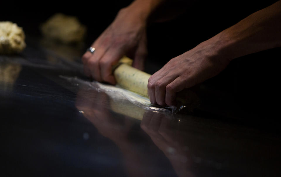 A staff member makes tarragon butter for a Turbot dish as he helps to prepare nearly 600 take-away orders at Sergio Herman's Le Pristine restaurant in Antwerp, Belgium, Friday, Nov. 6, 2020. Of all the many challenges the pandemic throws up for all kinds of professions, this one has been particularly tough: How to put a three-star chef into a takeout box. (AP Photo/Virginia Mayo)