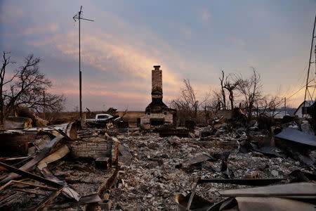 A chimney is all that stands in the footprint of a home destroyed by wildfires near Laverne, Oklahoma, U.S., March 12, 2017. REUTERS/Lucas Jackson