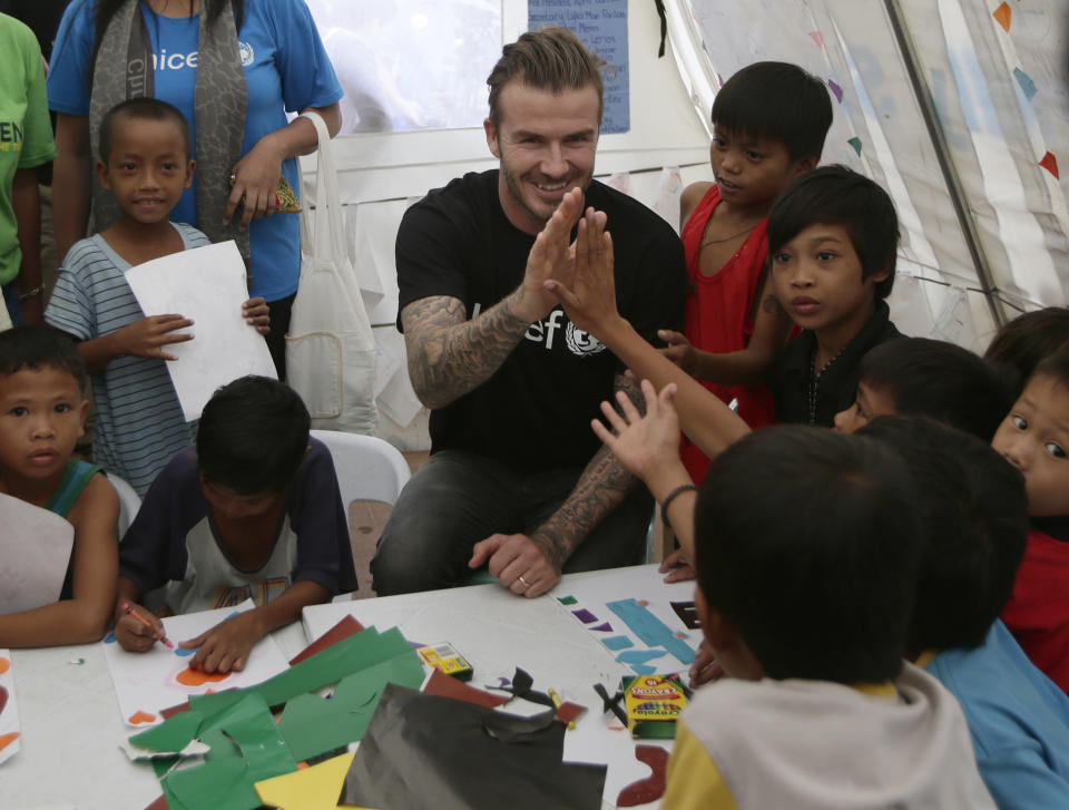 Former England soccer team captain David Beckham interacts with typhoon survivors during his visit to Typhoon Haiyan-hit Tacloban city, central Philippines, Thursday, Feb. 13, 2014. Beckham visited the storm-devastated Philippine city as part of UNICEF's relief efforts. (AP Photo/Bullit Marquez)