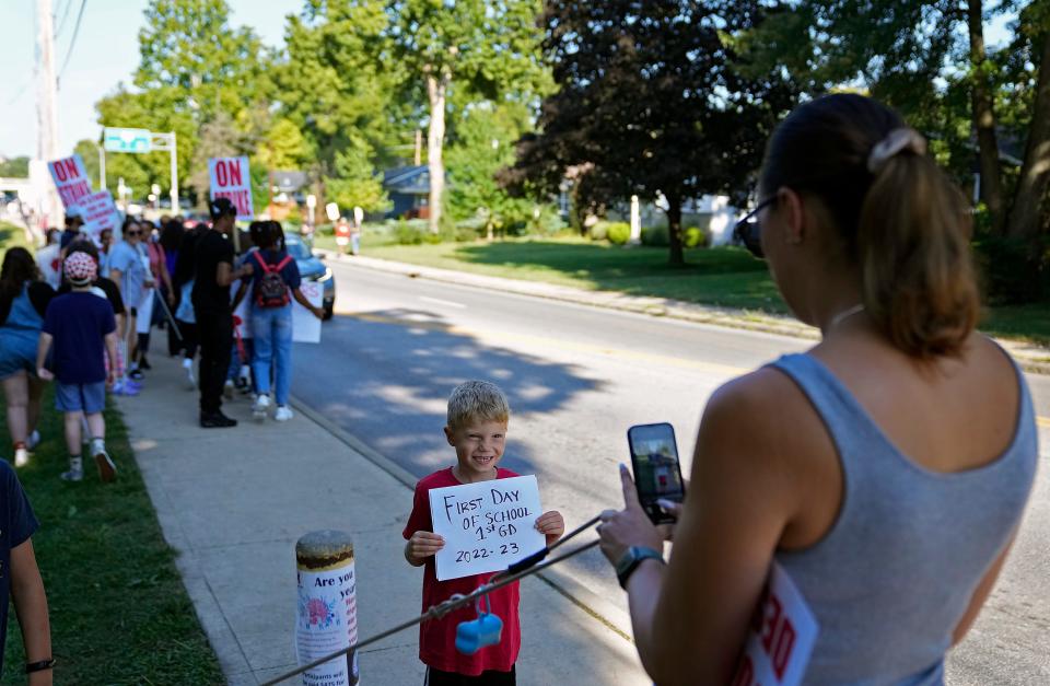 Amanda Mellott takes a "first day of school" photo of her son, Rhys, 6, a first grader at Ecole Kenwood French Immersion in front of the picket line at Whetstone High School on Wednesday.