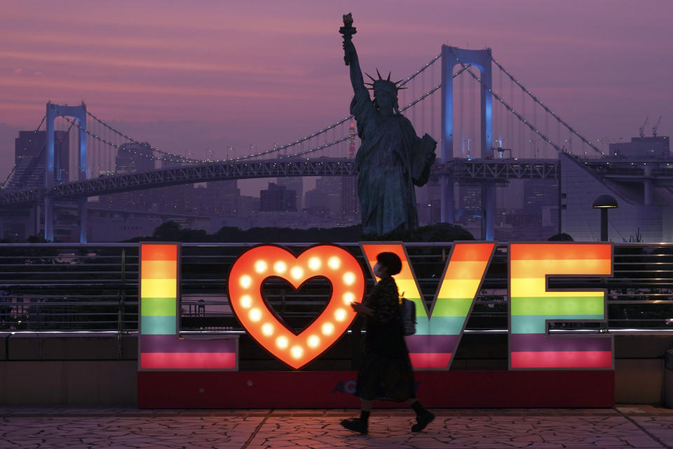 A visitor walks at Odaiba at sunset Wednesday, June 3, 2020, in Tokyo. A coronavirus state of emergency has been lifted, ending the restrictions nationwide as businesses began to reopen.(AP Photo/Eugene Hoshiko)