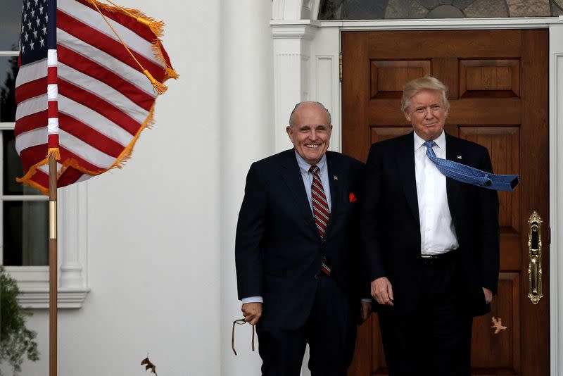 FILE PHOTO: U.S. President-elect Donald Trump stands with former New York City Mayor Rudolph Giuliani before their meeting at Trump National Golf Club in Bedminster