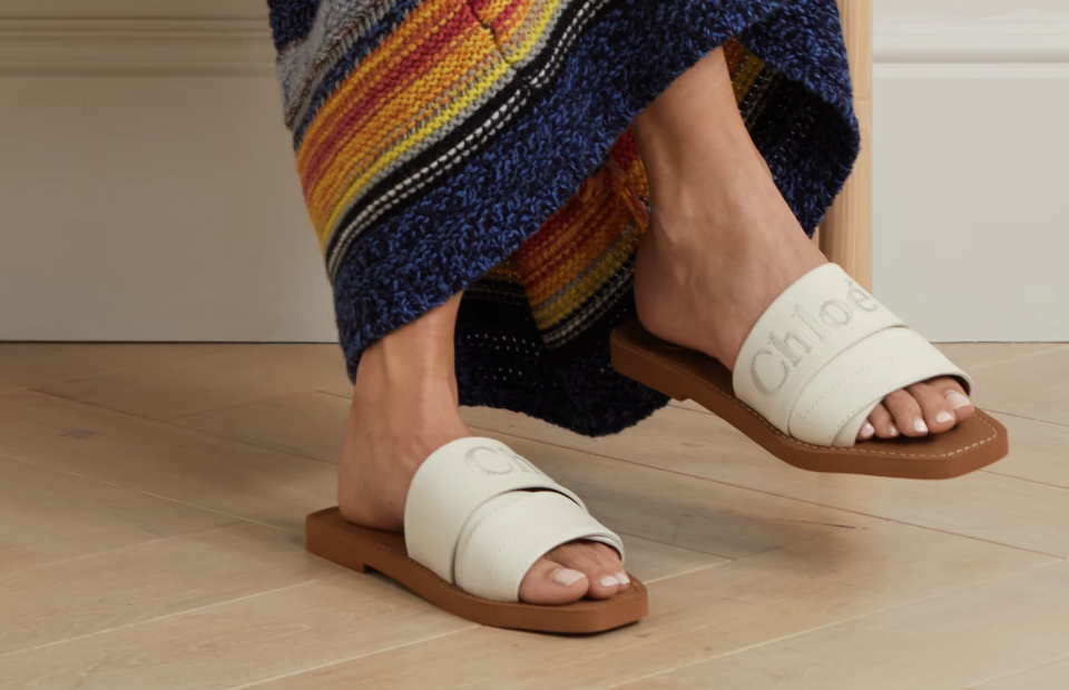 A model wearing Chloé Woody logo-embroidered leather slides. (PHOTO: Net-A-Porter)