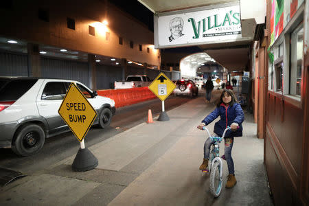 A girl rides her bicycle across the border from Mexico to the U.S. in Nogales, Arizona, U.S., January 30, 2017. REUTERS/Lucy Nicholson