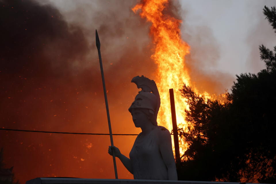 A statue of goddess Athena is seen as wildfire burns at Varympompi suburb north of Athens, Greece, August 3, 2021. REUTERS/Giorgos Moutafis     TPX IMAGES OF THE DAY