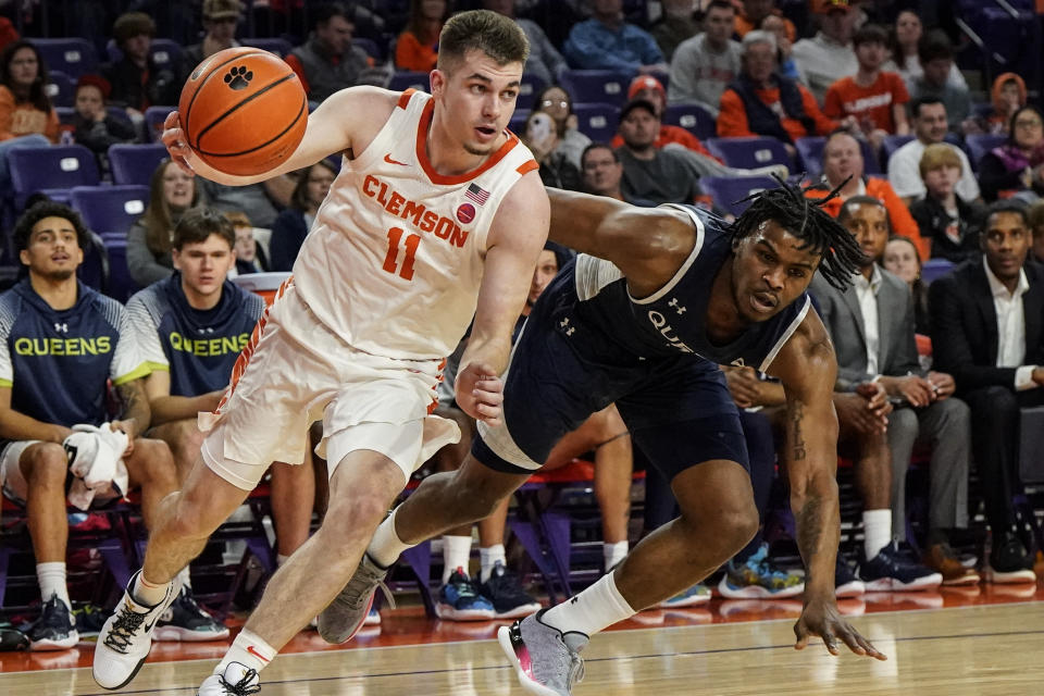 Clemson guard Joseph Girard III (11) moves the ball against Queens University guard AJ McKee (5) during the first half of an NCAA basketball game, Friday, Dec. 22, 2023, in Clemson, S.C. (AP Photo/Mike Stewart)