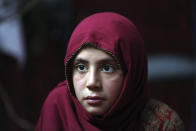 In this Thursday, May 30, 2019 photo, Shoghla, daughter of Farmanullah Shirzad whose family fled their village in Nangarhar province in late April as Islamic State group fighters swept through the area, poses for a photograph in their temporary home in the city of Jalalabad east of Kabul, Afghanistan. The Islamic State group has lost its caliphate in Syria and Iraq, but in the forbidding mountains of northeastern Afghanistan the group is expanding its footprint, recruiting new fighters and plotting attacks in the United States and other Western countries. (AP Photo/Rahmat Gul)