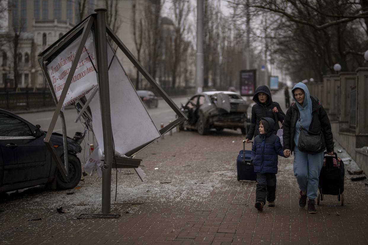A group of women and a boy walk to the train station as they try to leave Kyiv, Ukraine, Wednesday, March 2, 2022. Russian forces have escalated their attacks on crowded cities in what Ukraine's leader called a blatant campaign of terror.
