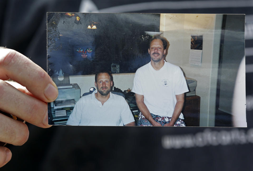 FILE - In this Oct. 2, 2017 file photo, Eric Paddock holds a photo of himself, left, and his brother, Las Vegas shooter Stephen Paddock, right, outside his home in Orlando, Fla. Letters addressing the gunman who in October 2017 unleashed the deadliest mass shooting in modern U.S. history in Las Vegas, apparently from an ex-convict who lived in Texas, foretell the carnage to come, according to documents obtained Friday, April 7, 2023. (AP Photo/John Raoux, File)