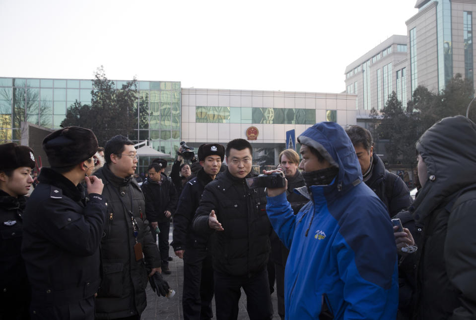 Chinese policemen urge foreign journalists to leave the Beijing's No. 1 Intermediate People's Court, where Xu Zhiyong is expected to stand trial, in Beijing Wednesday, Jan. 22, 2014. The trial of the prominent activist who has led a grassroots campaign demanding a fairer society and official accountability to better fight corruption started in Beijing, while police blocked journalists and supporters from getting near. Xu stood trial Wednesday, accused of disrupting public order. (AP Photo/Andy Wong)