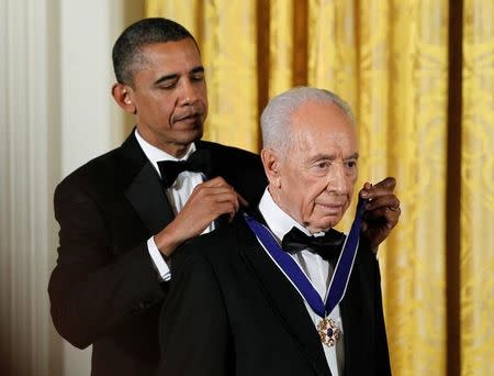 U.S. President Barack Obama (L) presents the Presidential Medal of Freedom to Israeli President Shimon Peres in the East Room of the White House in Washington in this June 13, 2012 file photo. REUTERS/Jason Reed/Files