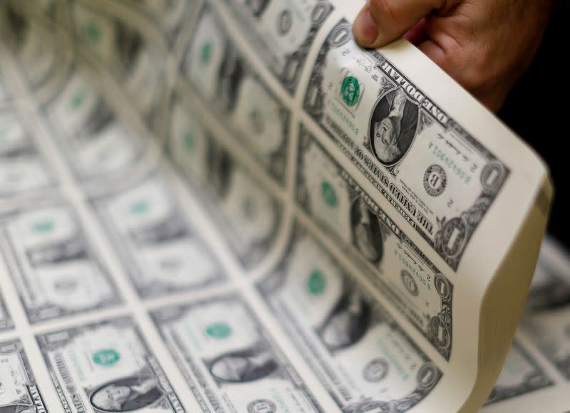 FILE PHOTO: United States one dollar bills are curled and inspected during production at the Bureau of Engraving and Printing in Washington