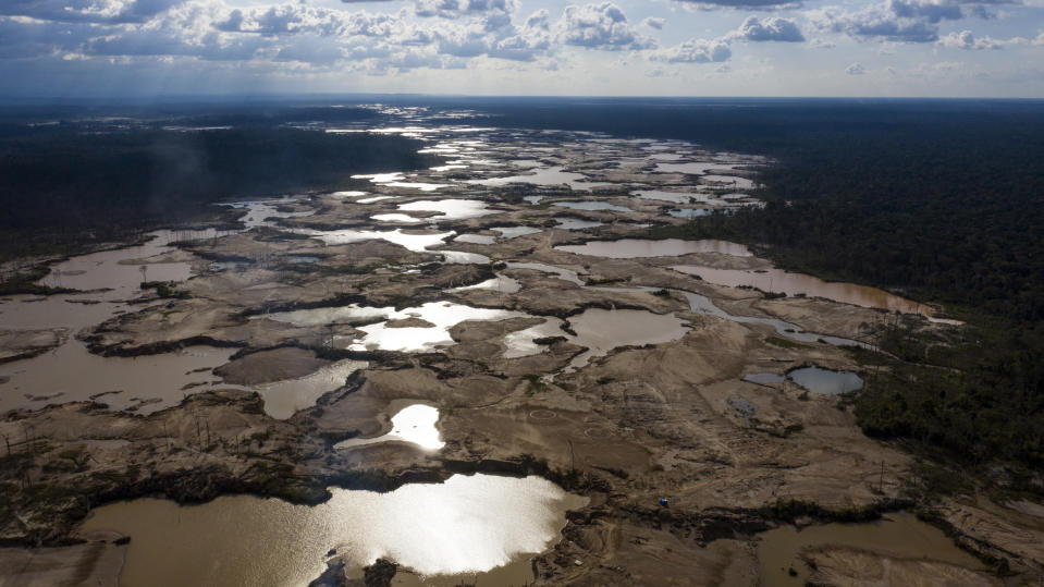 This March 28, 2019 photo shows thousands of hectares of Amazon jungle destroyed by illegal miners, in the Tambopata province, one of three that make up Peru's Madre de Dios department. After cutting and burning centuries-old trees, miners used diesel pumps to suck up deep layers of the earth, then pushed the soil through filters to separate out gold particles. To turn gold dust into nuggets, they stirred in mercury, which binds the gold together but also poisons the land. (AP Photo/Rodrigo Abd)