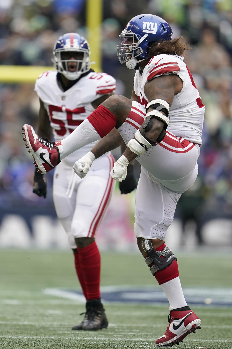 New York Giants defensive end Leonard Williams, right, celebrates in front of Jihad Ward after sacking Seattle Seahawks quarterback Geno Smith during the first half of an NFL football game in Seattle, Sunday, Oct. 30, 2022. (AP Photo/Marcio Jose Sanchez)