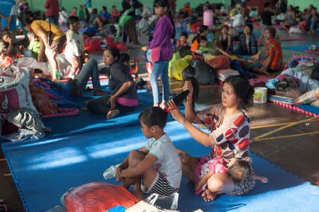 Evacuated villagers from locations near the summit of Mount Agung, an active volcano which is showing increased seismic activity, relax in a temporary shelter in Klungkung, on the resort island of Bali, Indonesia September 22, 2017 in this photo taken by Antara Foto. Antara Foto/Nyoman Budhiana/via REUTERS ATTENTION EDITORS - THIS IMAGE WAS PROVIDED BY A THIRD PARTY. MANDATORY CREDIT. INDONESIA OUT. NO COMMERCIAL OR EDITORIAL SALES IN INDONESIA.