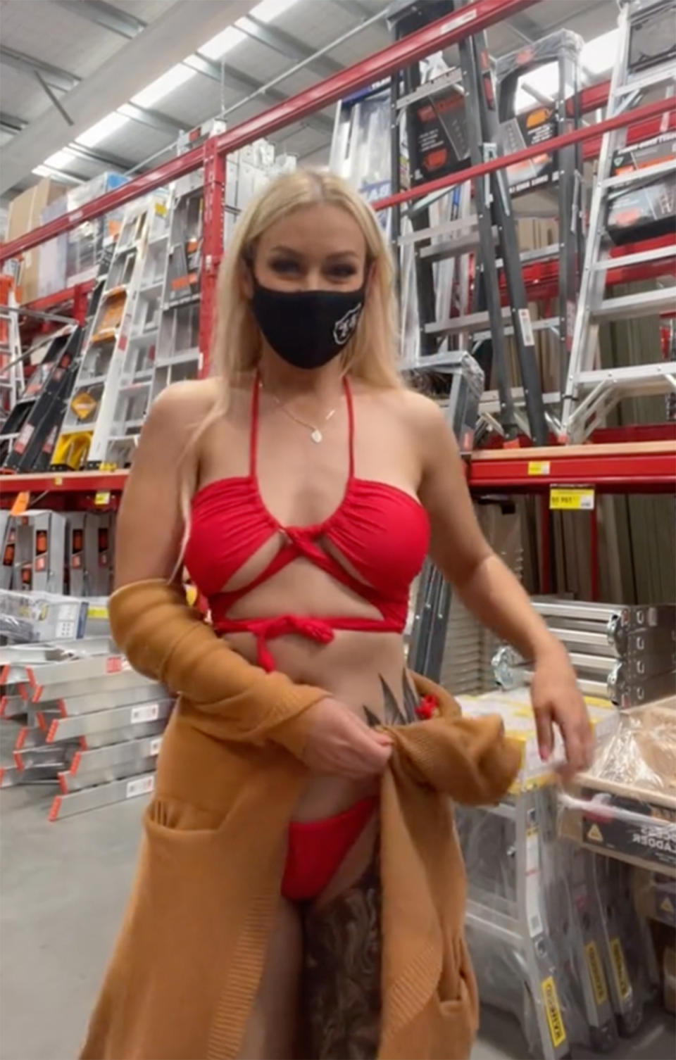 A woman wearing a red bikini films a TikTok dance in an aisle at Bunnings Warehouse. Photo: TikTok/wippa_snippa.