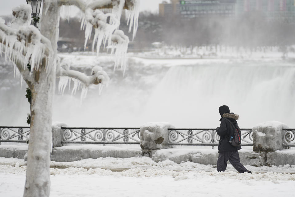 A man walks in the snow along the Niagara Parkway in Niagara Falls, Ontario, on January 27, 2021. (Photo by Geoff Robins / AFP) (Photo by GEOFF ROBINS/AFP via Getty Images)