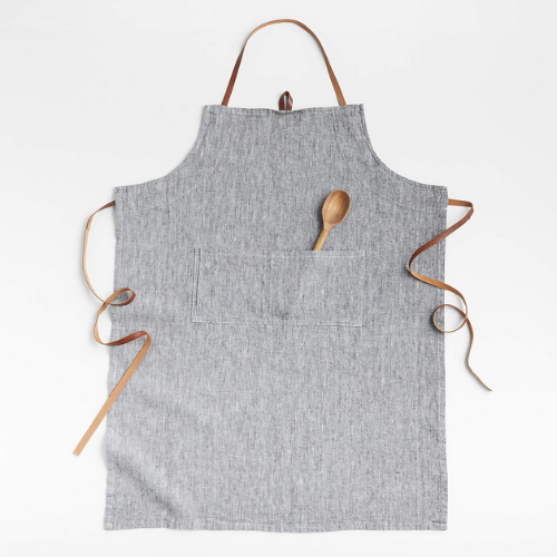 grey apron with a wooden spoon in pocket against white background
