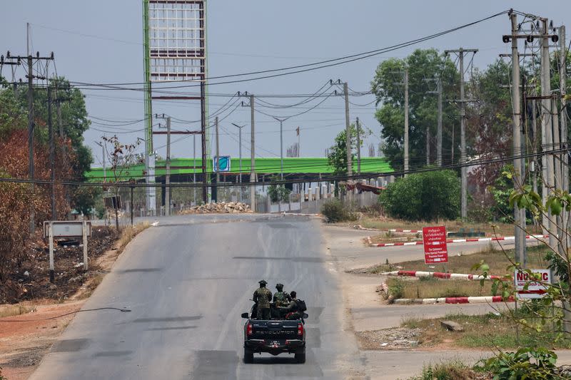 FILE PHOTO: Soldiers from the Karen National Liberation Army (KNLA) patrol on a vehicle, next to an area destroyed by Myanmar's airstrike in Myawaddy